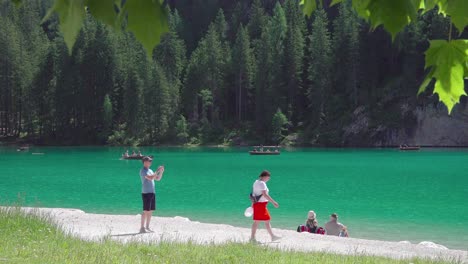 Ein-Junger-Mann-Fotografiert-Mit-Seinem-Handy-Seinen-Begleiter-Am-Ufer-Des-Pragser-Wildsees