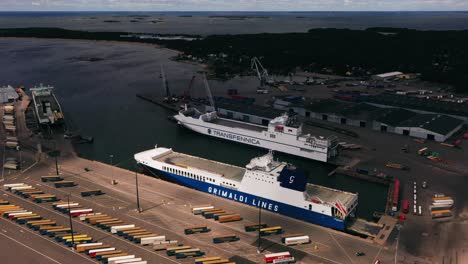 Vista-Aérea-De-Los-Buques-De-Carga-En-Una-Terminal-De-Envío,-Verano-En-Hanko,-Finlandia---Marcha-Atrás,-Inclinación,-Disparo-De-Drones