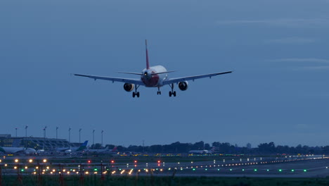 Lichtreflexionen-Unter-Dem-Flugzeugrumpf,-Der-Auf-Der-Beleuchteten-Start--Und-Landebahn-Des-Flughafens-Barcelona-Landet