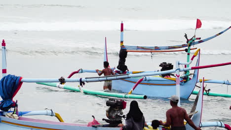 Toma-Panorámica-Y-Zoom-De-Pescadores-Poniendo-Canoa-Indonesia-Típica-En-El-Mar,-Bali