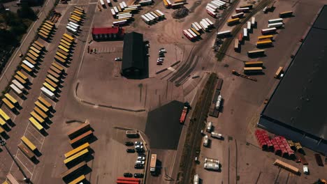 Luftaufnahme-Mit-Blick-Auf-Einen-LKW,-Der-Mitten-In-Der-Fracht-An-Einem-Versandterminal-Im-Sonnigen-Finnland-Fährt