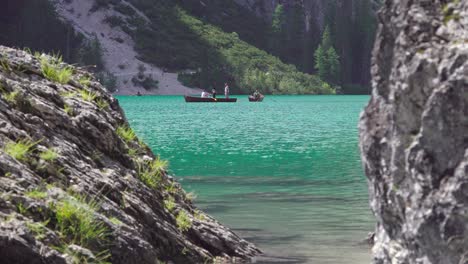 People,-most-probably-tourists,-enjoying-a-day-out-on-the-lake-using-rowing-boats,-as-well-as-hiking-around-the-lake