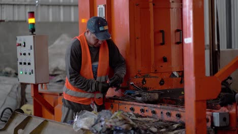 Un-Trabajador-En-Un-Compactador-Que-Prepara-Basura-Para-Su-Eliminación-Dentro-De-Una-Planta-De-Procesamiento-De-Residuos