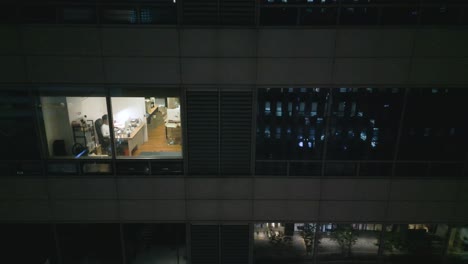 Man-working-late-in-his-apartment-in-Seoul-at-night-next-to-a-busy-bar-street,-South-Korea