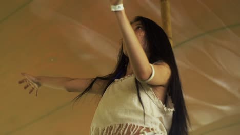 Asian-woman-wearing-organic-cotton-clothes-swinging-and-swaying-arms-during-ecstatic-dance-performance,-filmed-in-slow-motion-as-tight-medium-shot