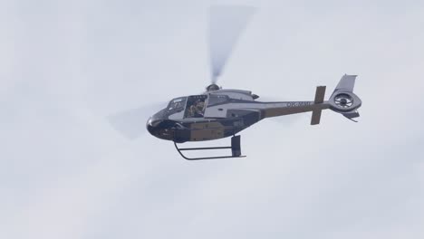 Military-Special-Units-Helicopter-With-Soldier-in-Open-Cockpit-Flying-in-the-Sky,-Low-Angle-View