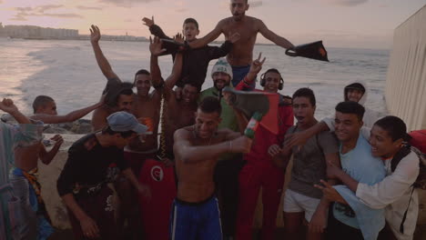 A-group-of-young-men-diving-in-the-Atlantic-Ocean-near-Hassan-II-mosque-in-Casablanca-cheer-for-the-camera-at-sunset