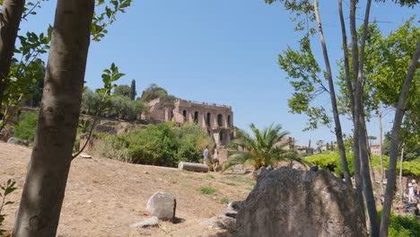 Couple-walks-through-the-Roman-Forum,-tourists-look-at-the-remains-of-the-Roman-Empire-in-Rome,-Italy