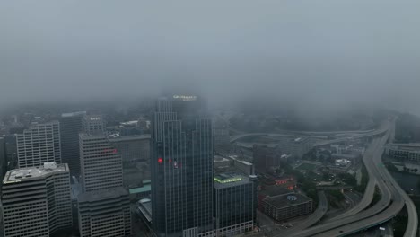 Aerial-view-through-low-clouds-towards-the-Great-American-tower,-dark,-cloudy-day-in-Cincinnati,-USA