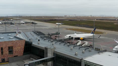 Edificio-Del-Aeropuerto-Keflavíkurflugvöllur-Con-Avión-Boeing-Estacionado-En-La-Puerta,-Antena