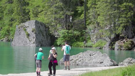 Grupos-De-Personas-Caminando-Y-Tomándose-Selfies-Del-Lago-Braies,-Que-A-Lo-Largo-De-Los-Años-Se-Ha-Convertido-En-Un-Destino-Turístico-Muy-Famoso