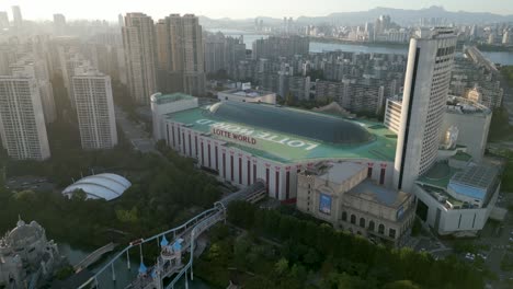 Drone-Shot-of-Lotte-World-with-amusement-park-at-sunset,-Seoul,-South-Korea