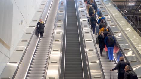 Cerca-De-Personas-En-Escaleras-Mecánicas-En-El-Aeropuerto-De-Helsinki-Vantaa,-Finlandia