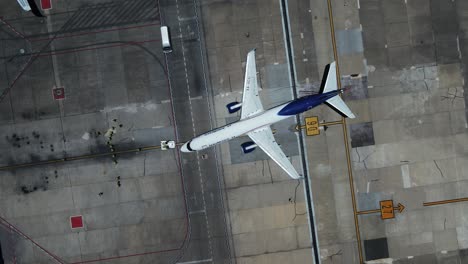 Vista-Aérea-De-Un-Vehículo-Remolcador-Empujando-Un-Avión-En-El-Aeródromo,-En-La-Ciudad-De-México