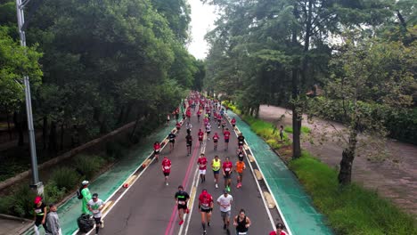 Toma-De-Dron-Hacia-Arriba-De-Los-Corredores-De-La-Maratón-De-La-Ciudad-De-México-Mientras-Corren-Por-La-Avenida-Paseo-De-La-Reforma-A-Su-Propio-Ritmo