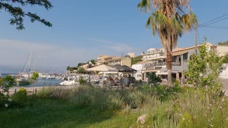 View-of-the-coast-of-island-Corfu-and-harbor-in-Kassiopi,-anchored-sailboats