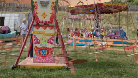 Child-rides-swing-carousel-merry-go-round-ride-in-amusement-park-on-a-bright-sunny-day-during-summer-August-2022