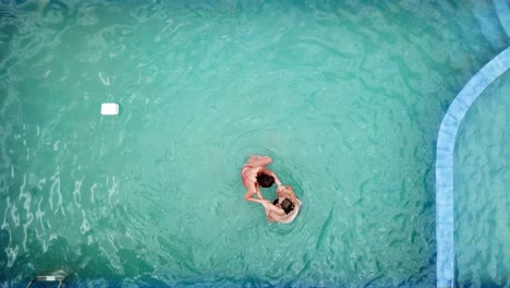 Drohnenansicht-Von-Oben-Auf-Eine-Gruppe-Von-Mädchen,-Die-Beim-Schwimmen-In-Einem-Pool-Spielen