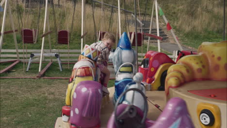 Little-girl-rides-the-merry-go-round-carousel-horse-during-a-day-out-in-amusement-park-Scarborough-August-2022