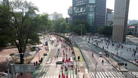 Toma-De-Drones-Hacia-Atrás-De-Los-Corredores-De-La-Maratón-De-La-Ciudad-Mientras-Pasan-Por-Los-Grandes-Rascacielos-De-La-Ciudad