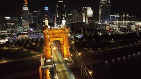 Car-driving-on-the-illuminated-Roebling-Bridge-in-Cincinnati,-USA---aerial-view