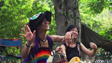 Dos-Mujeres-Asiáticas-Se-Visten-Con-Ropa-De-Estilo-Hipster-Girando-Las-Manos-En-Movimiento-Circular-Durante-Una-Actuación-De-Baile-Extática-Con-Paisajes-Al-Aire-Libre,-Filmadas-Como-Un-Primer-Plano-Medio-En-Cámara-Lenta