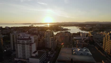 Aerial-view-of-buildings-in-downtown-Victoria,-sunny-evening-in-BC,-Canada---ascending,-drone-shot