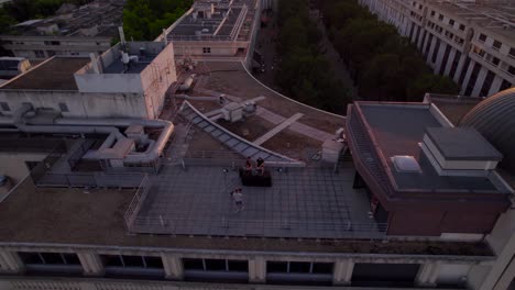 Toma-Aérea-De-Un-Camarógrafo-Filmando-Un-Video-Musical-Con-Dj-Disc-Jockey-En-El-Techo-De-Edificios-De-Gran-Altura-Al-Atardecer---Francia,-Montpellier