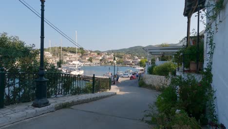 Vista-De-Veleros-Anclados-En-El-Puerto-Deportivo,-Turistas-En-La-Costa-En-Kassiopi,-Corfú,-Grecia