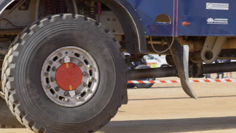 Dakar-Rally-Scene-On-Desert-Landscape-With-Wheels-Of-Huge-Rally-Truck-Driving-In-Foreground