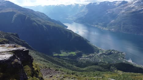 Amigos-Almorzando-Juntos-En-El-Mirador-A-Lo-Largo-De-La-Ruta-De-Senderismo-De-Dronningstien-Queens-Entre-Kinsarvik-Y-Lofthus-En-Hardanger-Noruega---Personas-Aéreas-Que-Pasan-Y-Revelan-Una-Vista-Impresionante