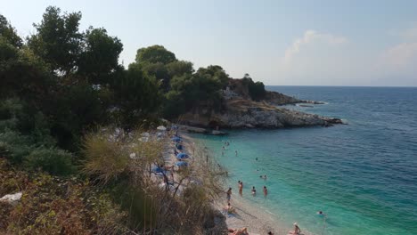 Tourists-on-crystal-clear-turquoise-water-from-Bataria-beach-in-Kassiopi,-Corfu-Island