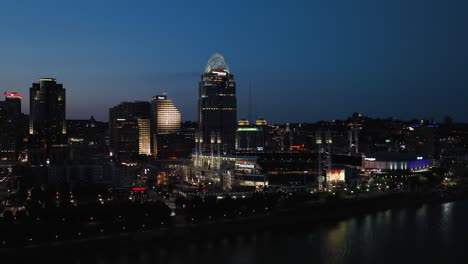 Luftaufnahme-über-Den-Ohio-River,-In-Richtung-Des-Beleuchteten-Great-American-Ball-Park,-Abenddämmerung-In-Cincinnati,-USA---Aufgang,-Drohnenaufnahme