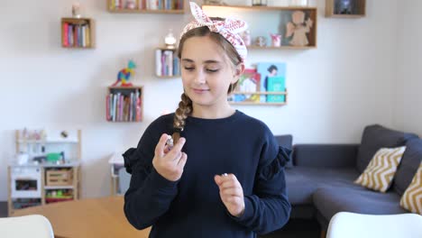 From-bottom-to-top-shot-of-cute-happy-young-girl-taking-Parfum-and-spraying-indoors-in-living-room