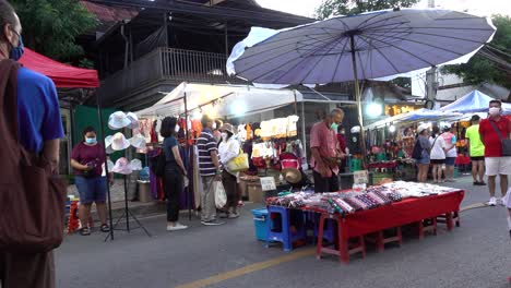 Menschen-Stehen-Still,-Während-Die-Nationalhymne-Auf-Dem-Markt-In-Thailand-Gespielt-Wird