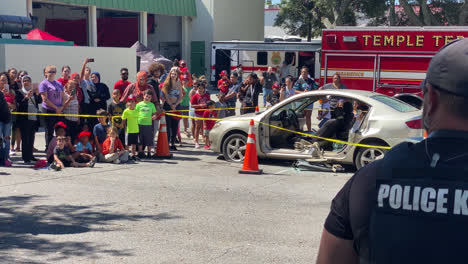 Oficial-De-Policía-Dando-órdenes-Y-Paseando-A-Un-Perro-Policía-Por-Una-Multitud-De-Personas-Frente-A-La-Estación-De-Bomberos-De-Temple-Terrace-Florida,-En-Un-Evento-De-Seguridad-E-Incendios