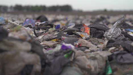 Non-recyclable-waste-dumped-in-a-landfill.-Close-up,-handheld