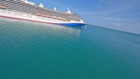 Drone-De-Carreras-Aéreas-Fpv-Volando-Sobre-Crucero-Amarrado-Y-Pueblo-Turístico-De-Cala-ámbar,-Puerto-Plata-En-República-Dominicana