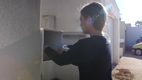 Close-up-shot-of-excited-young-girl-opening-letterbox-and-taking-package---slow-motion