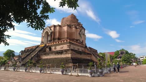 Two-tourists-walking-around-Temple-Grounds-of-Wat-Chedi-Luang-in-Chiang-Mai,-Thailand