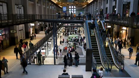 Escalators-and-many-people-within-Battersea-Power-Station,-London,-United-Kingdom