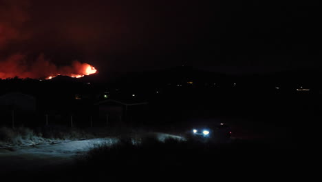 Ein-Auto,-Das-Nachts-Von-Einem-Waldbrandort-Fährt