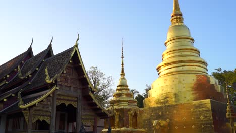 Slow-tilt-down-reveal-over-Temple-Grounds-with-tourists-at-Wat-Phra-Singh-in-Chiang-Mai,-Thailand