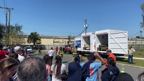 Florida-Fire-Sprinkler-Association-perform-an-on-site-demonstration-on-fire-sprinklers-saving-lives-to-remind-everyone-about-fire-safety-in-Tampa,-Florida,-Shot-taken-from-the-back