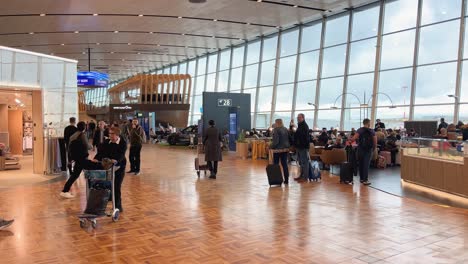 Helsinki-Airport-gate-area-people-shopping,-waiting-at-gate-and-walking