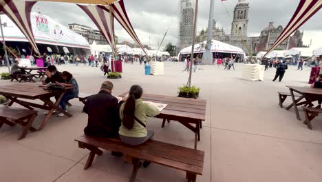 Schuss-Eines-Paares,-Das-Morgens-Auf-Dem-Zocalo-Von-Mexiko-stadt-Die-Zeitung-Liest