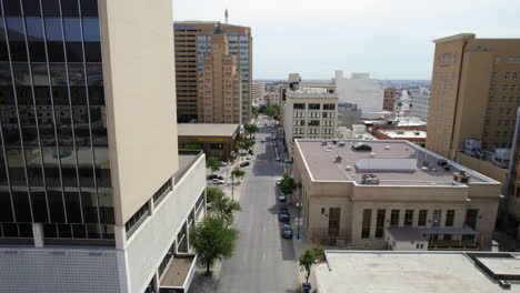 Aerial-Drone-Establishing-Shot-Flying-Low-Through-Urban-Downtown-Street-With-Low-Traffic-During-The-Day