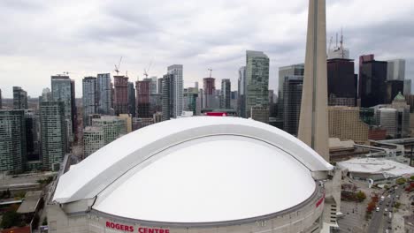 Vista-Aérea-Del-Centro-De-Rogers-Y-La-Torre-Cn-En-Toronto-Nublado,-Canadá---Dando-Vueltas,-Inclinación,-Disparo-De-Drones