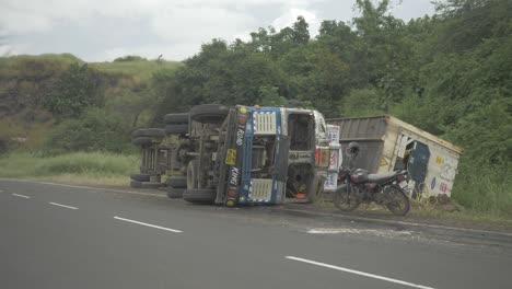 A-lorry-truck-carrying-a-cold-storage-container-toppled-in-an-accident-due-to-oversteering-on-a-downhill-ghat-section-on-an-Indian-highway-in-4k-slow-motion