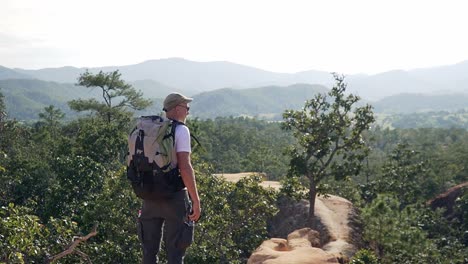 Backpacker-standing-on-the-edge-of-a-canyon-ejoying-the-view